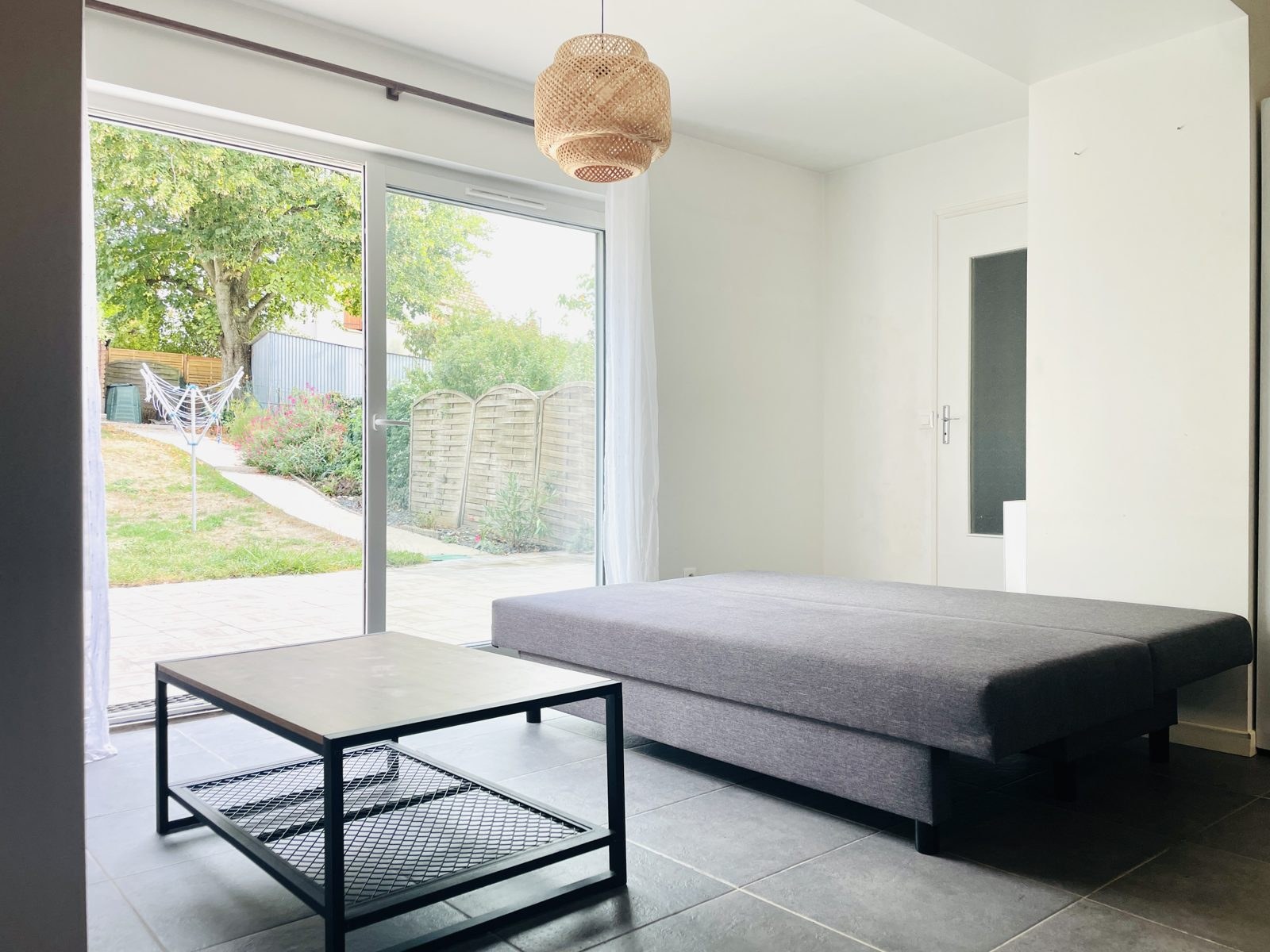 Maison avec jardin – Coin salon avec baie vitrée sur la terrasse